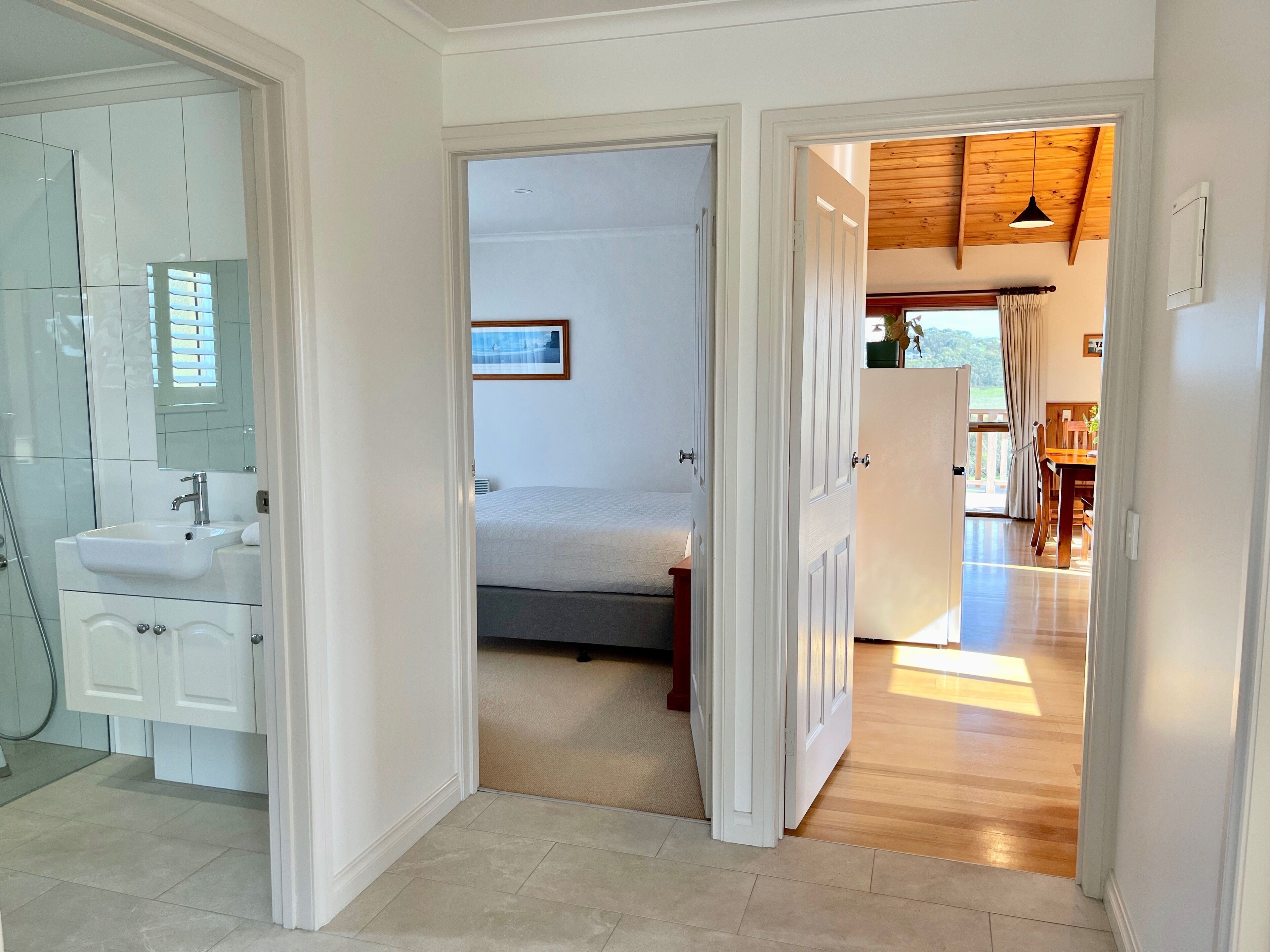 Habitación de hotel con baño, cama y zona de comedor.
