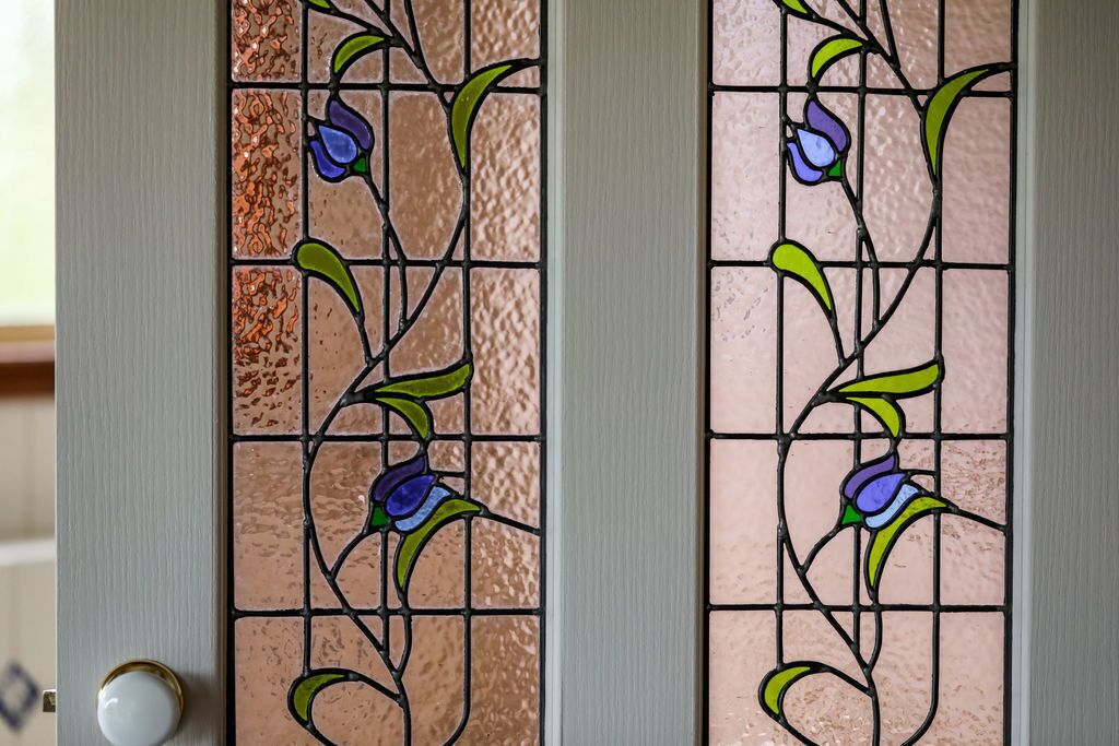 A door with a stained glass design featuring floral patterns.