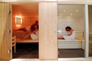 Una sauna con bancos de madera y un panel de vidrio.