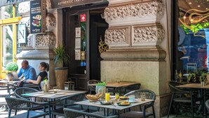An outdoor dining area with tables and chairs, a menu board, and a sign for 'Authentic Thai Food'. - Andrassy Thai Hotel (Budapest)
