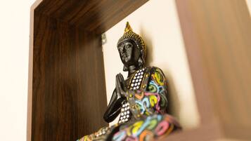 Una estatua de Buda con diseños coloridos, ubicada en un marco de madera.