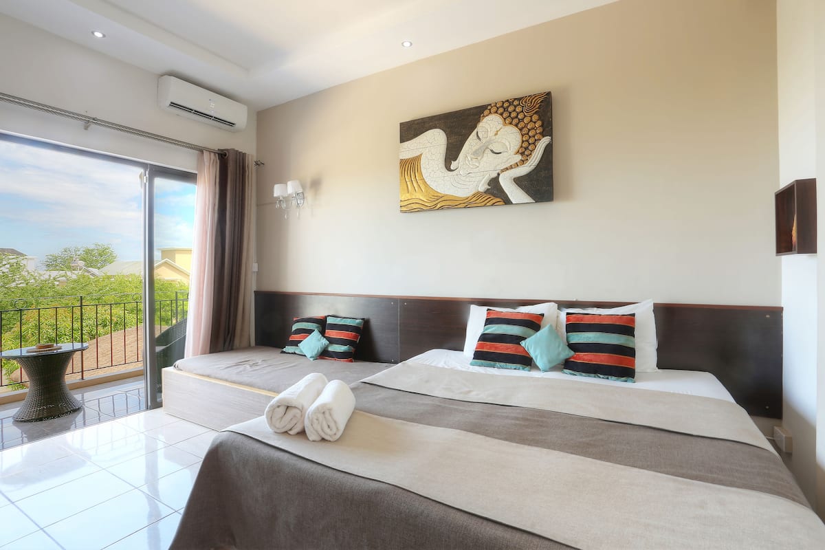 Ein Hotelzimmer mit einem großen Bett, einem Balkon mit Blick und einem Bild an der Wand.
