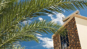 A building with a brick facade and a clear blue sky in the background. - L'Oiseau de l'Océan (Flic-en-Flac)