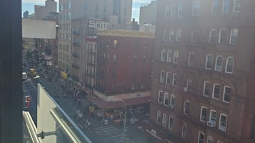 A city street with buildings, a pedestrian walkway, and a clear sky.