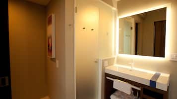 Une salle de bain moderne avec un meuble-lavabo blanc, un grand miroir et un porte-serviettes.