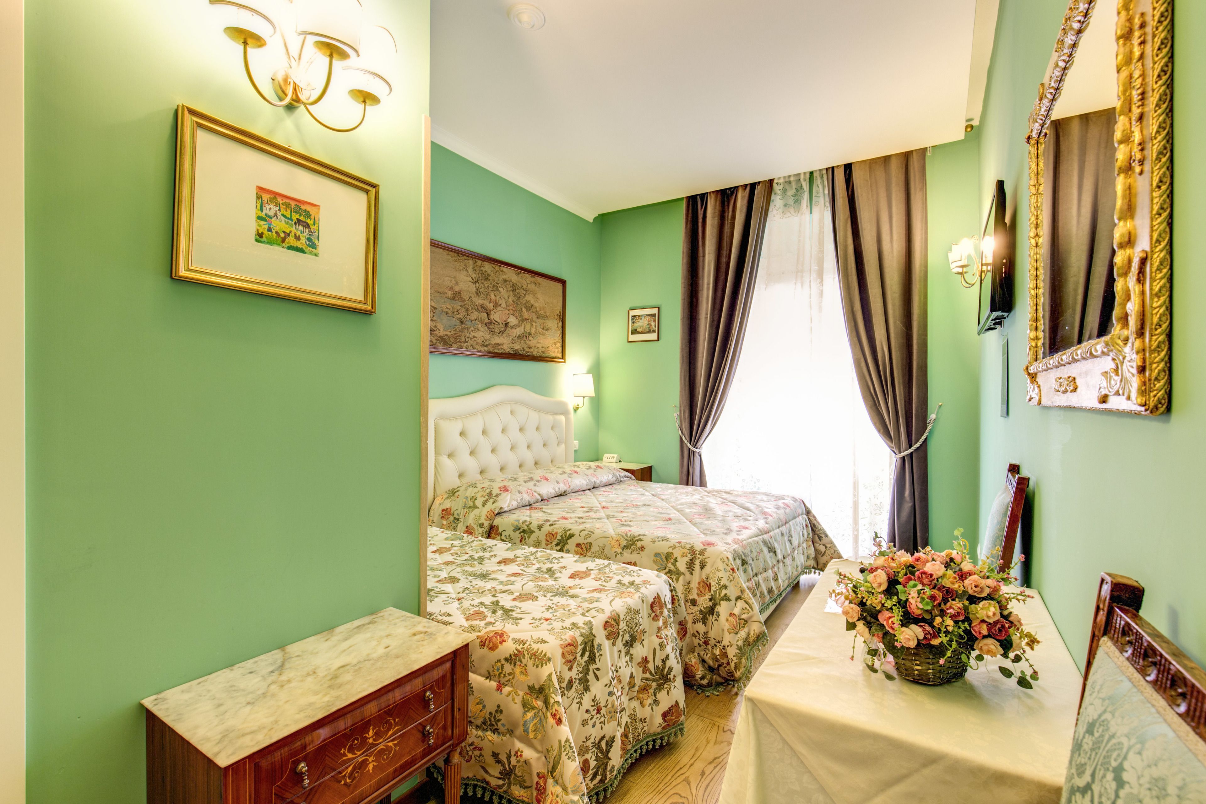 Une chambre avec deux lits, une commode, une coiffeuse et un miroir.