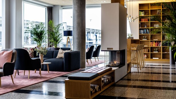 Un hall d’entrée moderne doté d’une cheminée, d’un espace salon et d’une bibliothèque.