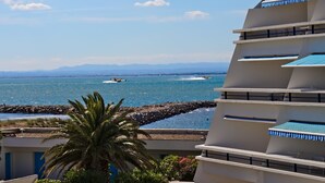 Un hotel moderno con varios balcones con vistas a la costa.