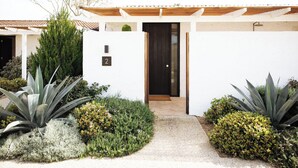 A modern house with a white exterior, a dark door, and a number '2' sign. - The Oaks Ranch (Mossy Point)