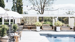 An outdoor pool area with seating arrangements and potted plants. - The Oaks Ranch (Mossy Point)