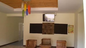 A room with a wooden ceiling, a patterned floor, and three wooden chairs. - Phuket7-inn Hotel (Chalong)