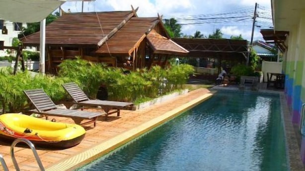 A swimming pool with lounge chairs and a yellow inflatable raft. - Phuket7-inn Hotel (Chalong)