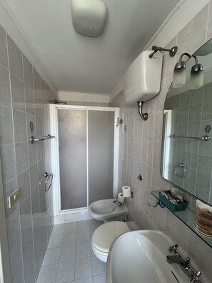 Vierpersoonskamer, uitzicht op zee | Badkamer | Een douche, een haardroger, handdoeken