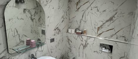 A bathroom with a large sink, a bidet, and a mirror.