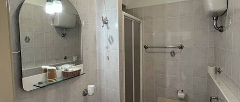 A bathroom with a sink, toilet, and shower area.