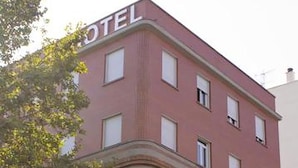 Un hotel con fachada roja y numerosas ventanas.