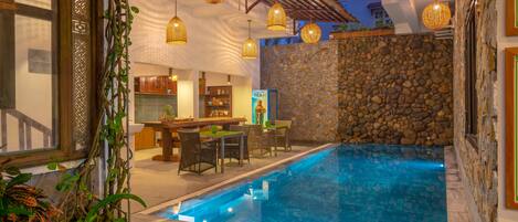 Una piscina al aire libre, sillones reclinables de piscina