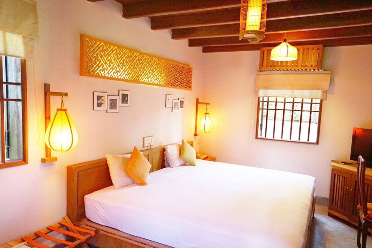 Une chambre à coucher avec un grand lit, une tête de lit en bois et deux lampes de chevet.