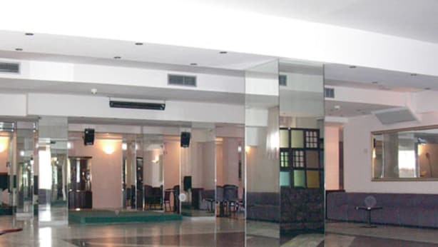 A lobby with a glass partition, seating area, and a reception desk. - Hotel Excelsior (Latina)