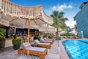 A poolside area with lounge chairs and umbrellas, a bar, and a pool. - Principal New Leisure Hotel (Katerini)