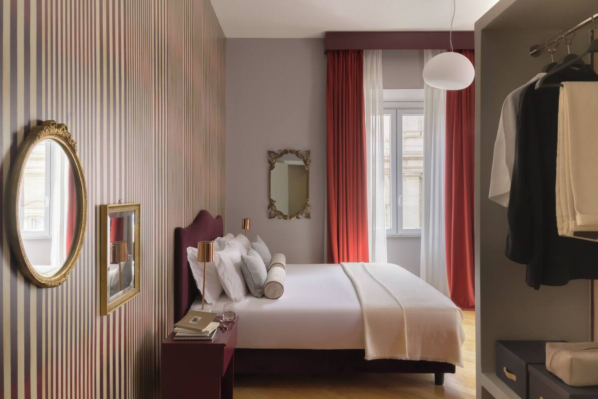 Ein Hotelzimmer mit Bett, Kommode, Spiegel und Kleiderschrank.