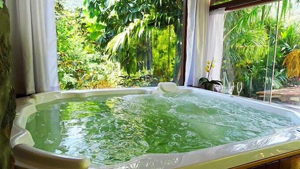 A hot tub with a view of lush greenery. - Pousada Riacho dos Cambucás (Angra dos Reis)