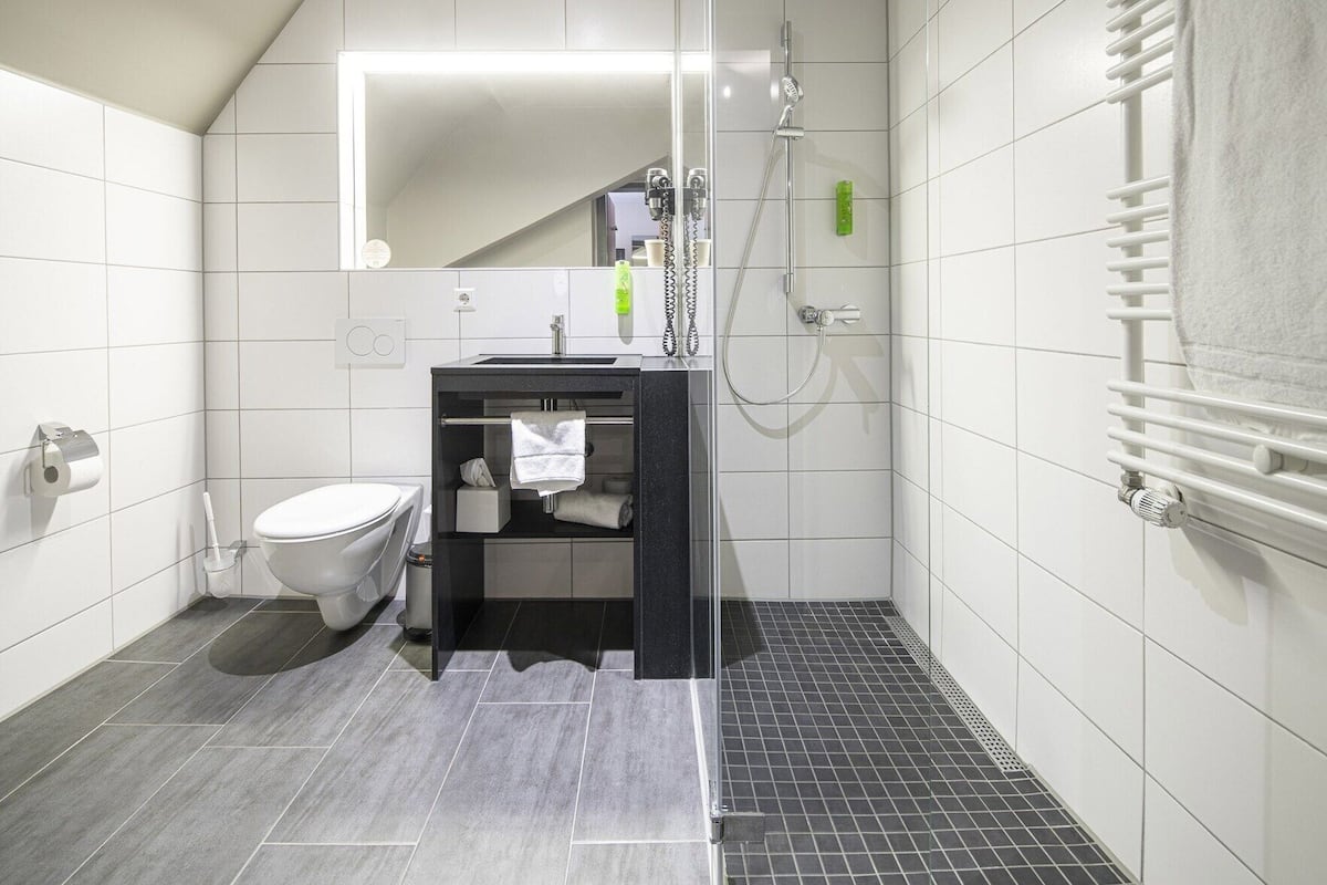 Badkamer | Een douche, een haardroger, handdoeken