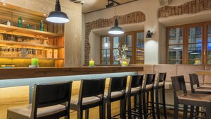 A bar area with wooden shelves, bar stools, and pendant lighting.