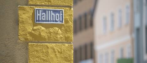 Un letrero en una pared amarilla con el nombre 'Hallhof'.