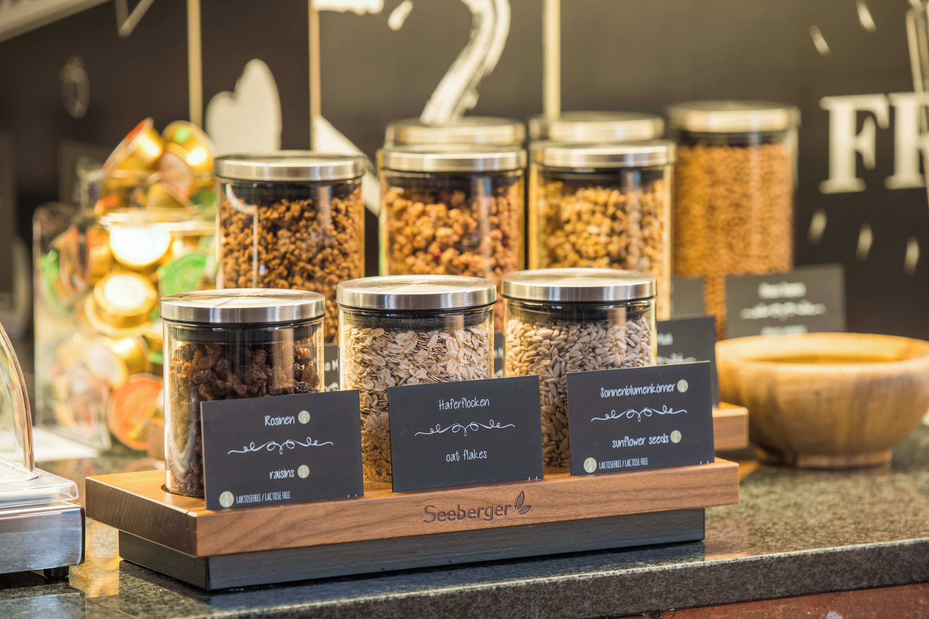 A display of various food items in jars with labels, including 'Kasinen,' 'Hafermolen,' and 'Sonnenblumenkern.'