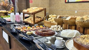 Un buffet proposant une variété de produits de boulangerie, de pâtisseries et de condiments.
