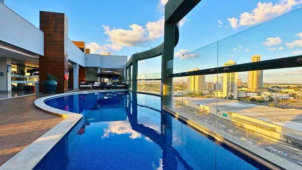 Une piscine sur le toit offrant une vue sur la ville, une architecture moderne et un espace de détente.