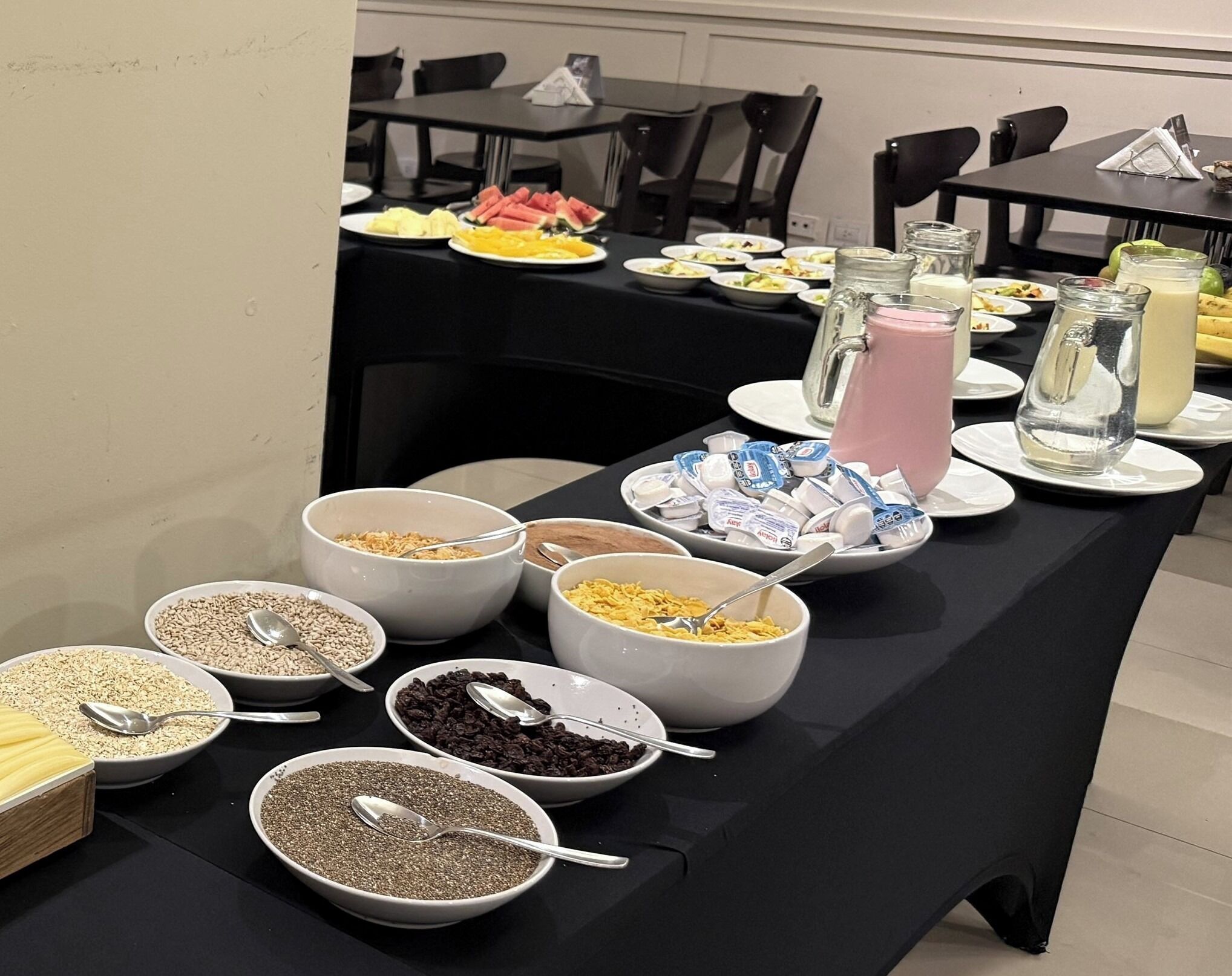 A buffet table with various food items and condiments.