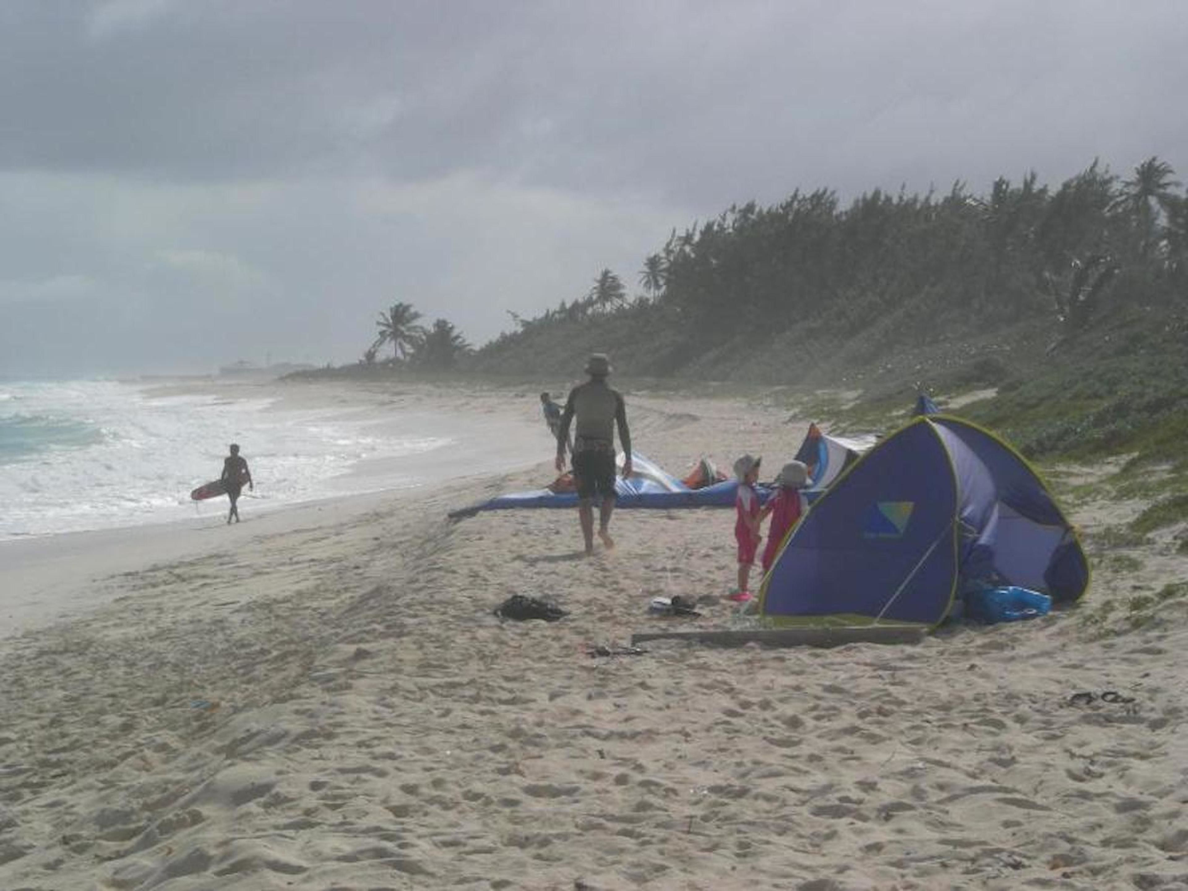 Une plage avec une tente et une planche de surf.
