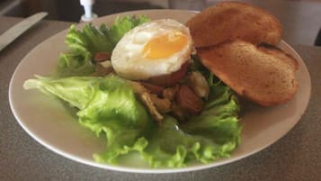 A plate with a salad, a fried egg, and two slices of toast.