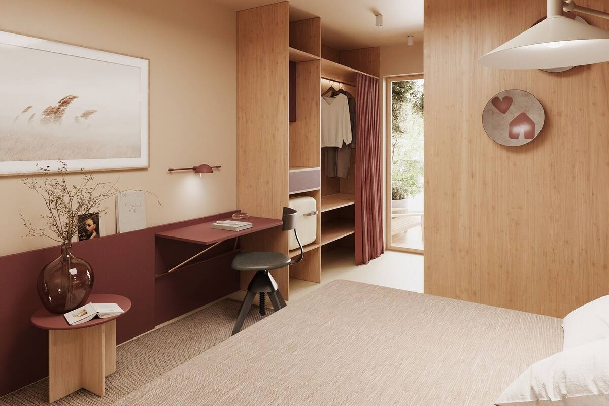 A modern bedroom with a bed, a desk, and a wardrobe.