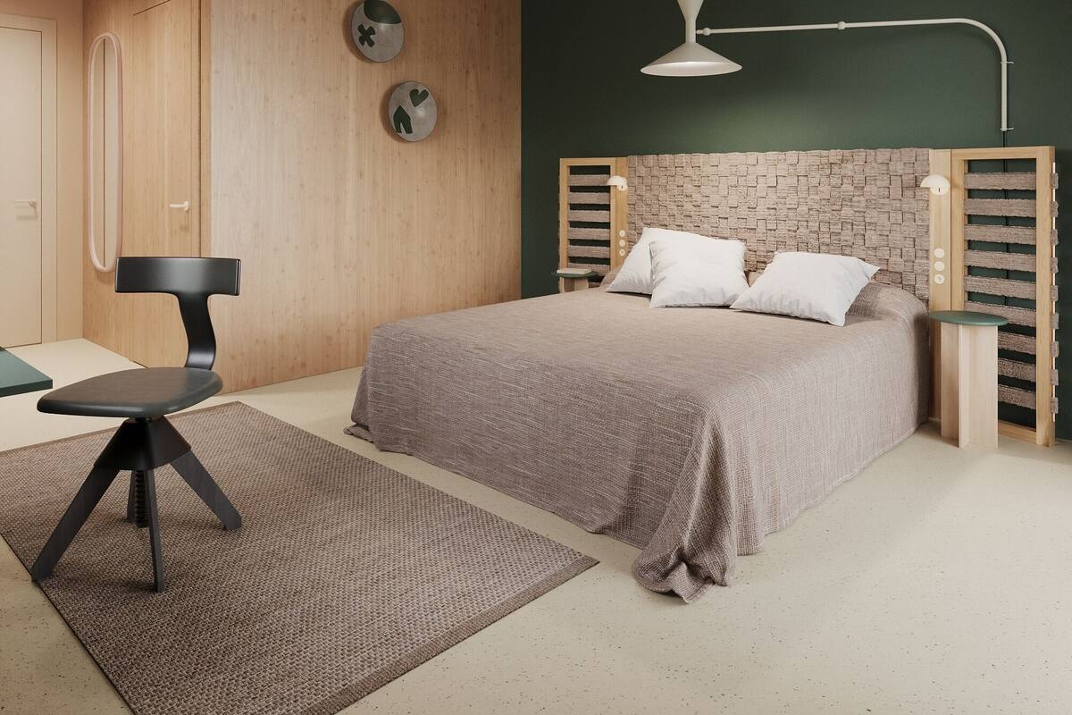 A modern bedroom with a bed, a desk, and a chair.