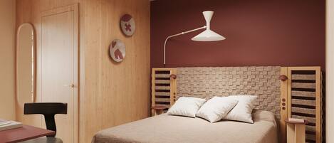 A bedroom with a bed, a desk, a chair, a ceiling fan, and a wall-mounted lamp.
