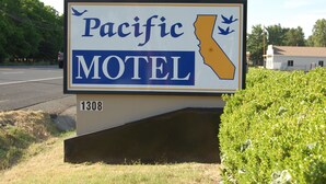 A motel sign with a state outline and the name 'Pacific Motel'. - Pacific Motel (Gridley)