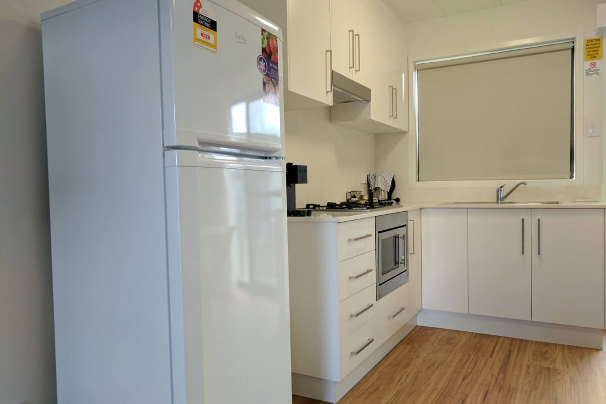 open plan motel style air conditioned cabin | private kitchen | full-sized fridge, microwave, stovetop, coffee/tea maker