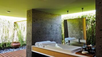 Un baño moderno con un espejo grande, un lavamanos blanco y un tocador de madera.