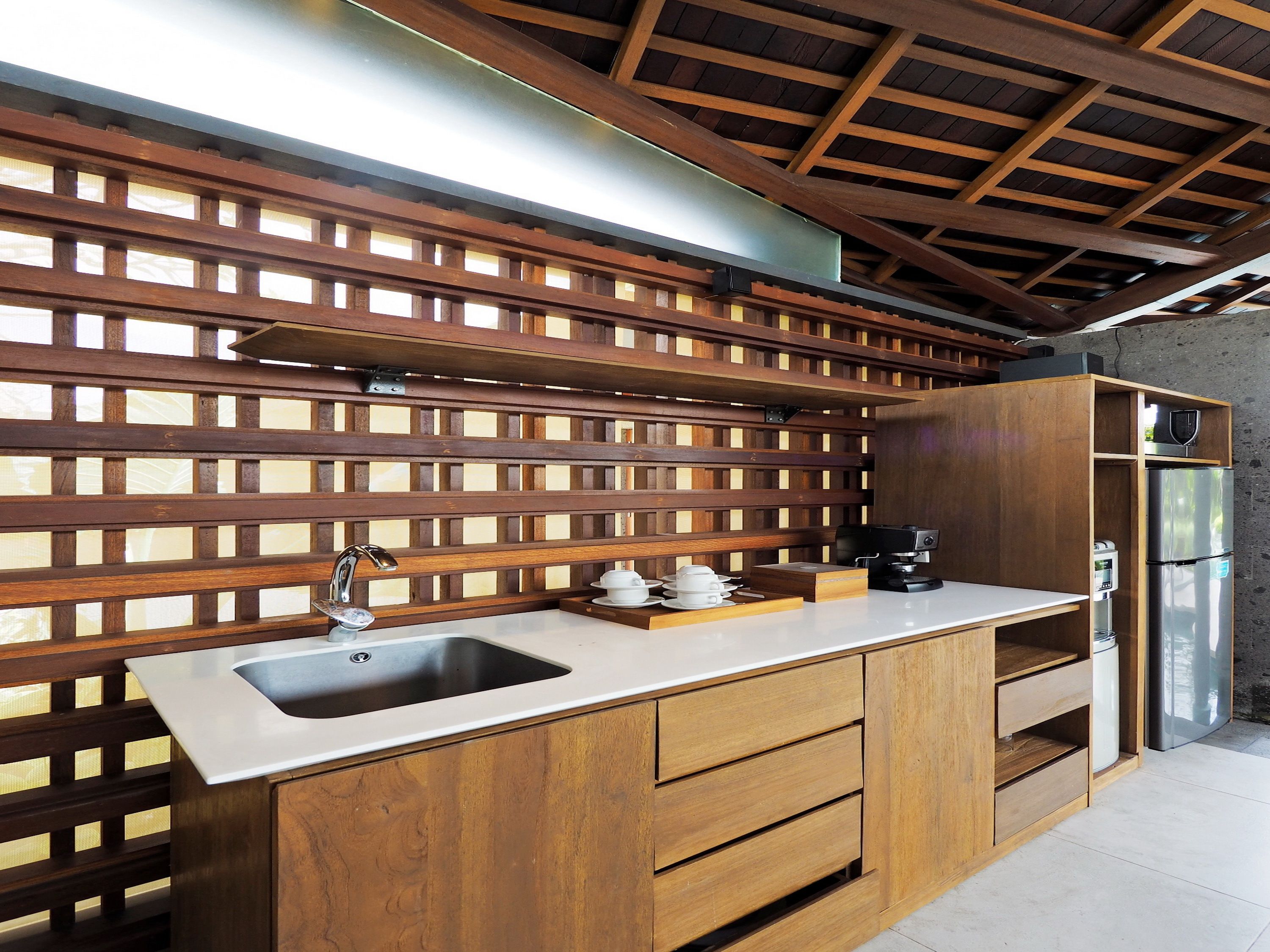 Una cocina con encimera de madera, un lavamanos y un refrigerador de acero inoxidable.