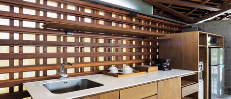 Una cocina con encimera de madera, un lavamanos y un refrigerador de acero inoxidable.