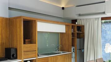 A modern kitchen with wooden cabinetry, a built-in sink, and a dining area with a table and chairs.