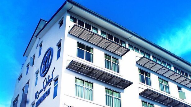 Un hotel de varios pisos con un diseño moderno, con balcones y ventanas amplias.