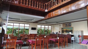 A spacious dining area with wooden furniture and large windows. - Angkor Vattanak Pheap Hotel (Siem Reap)