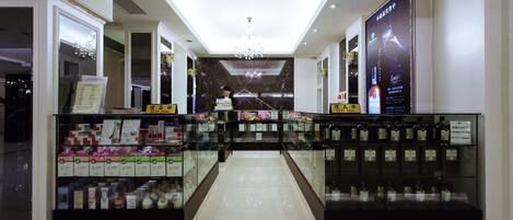 A well-lit shopping area with glass display cases and a central staircase.