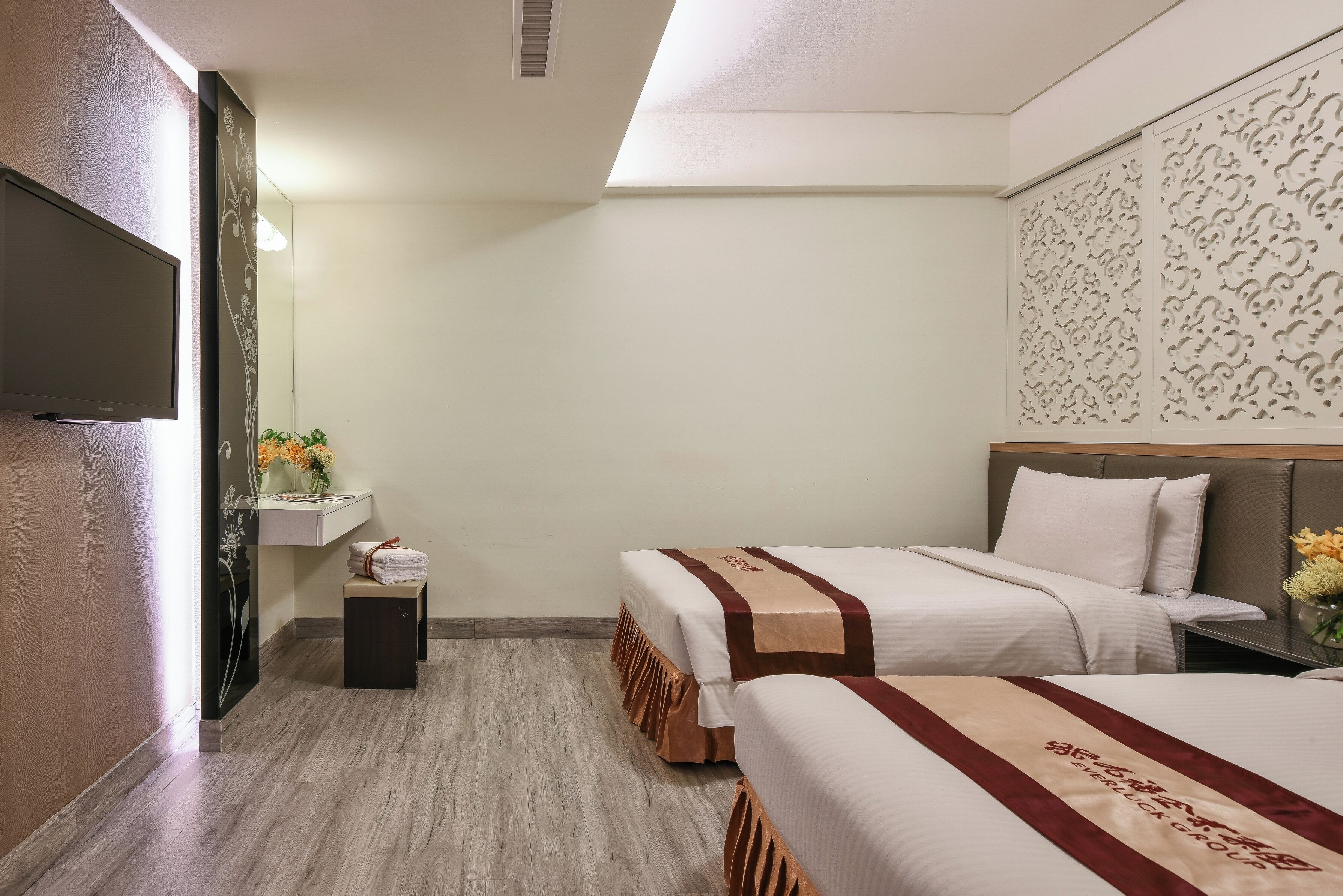 A hotel room with a bed, bedside table, and a TV.