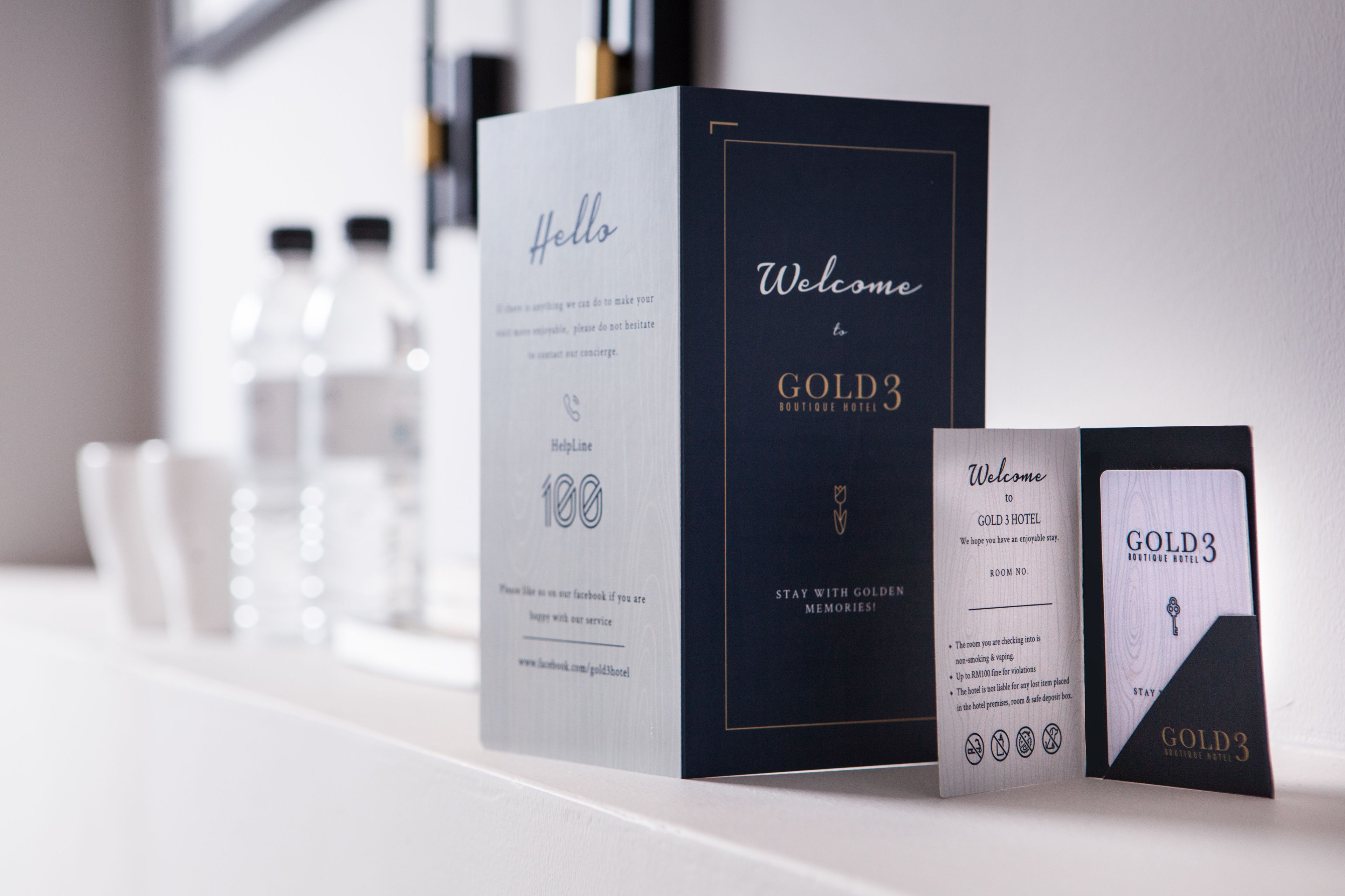 A set of hotel welcome boxes for the Gold3 Boutique Hotel, including a large box and a smaller card.
