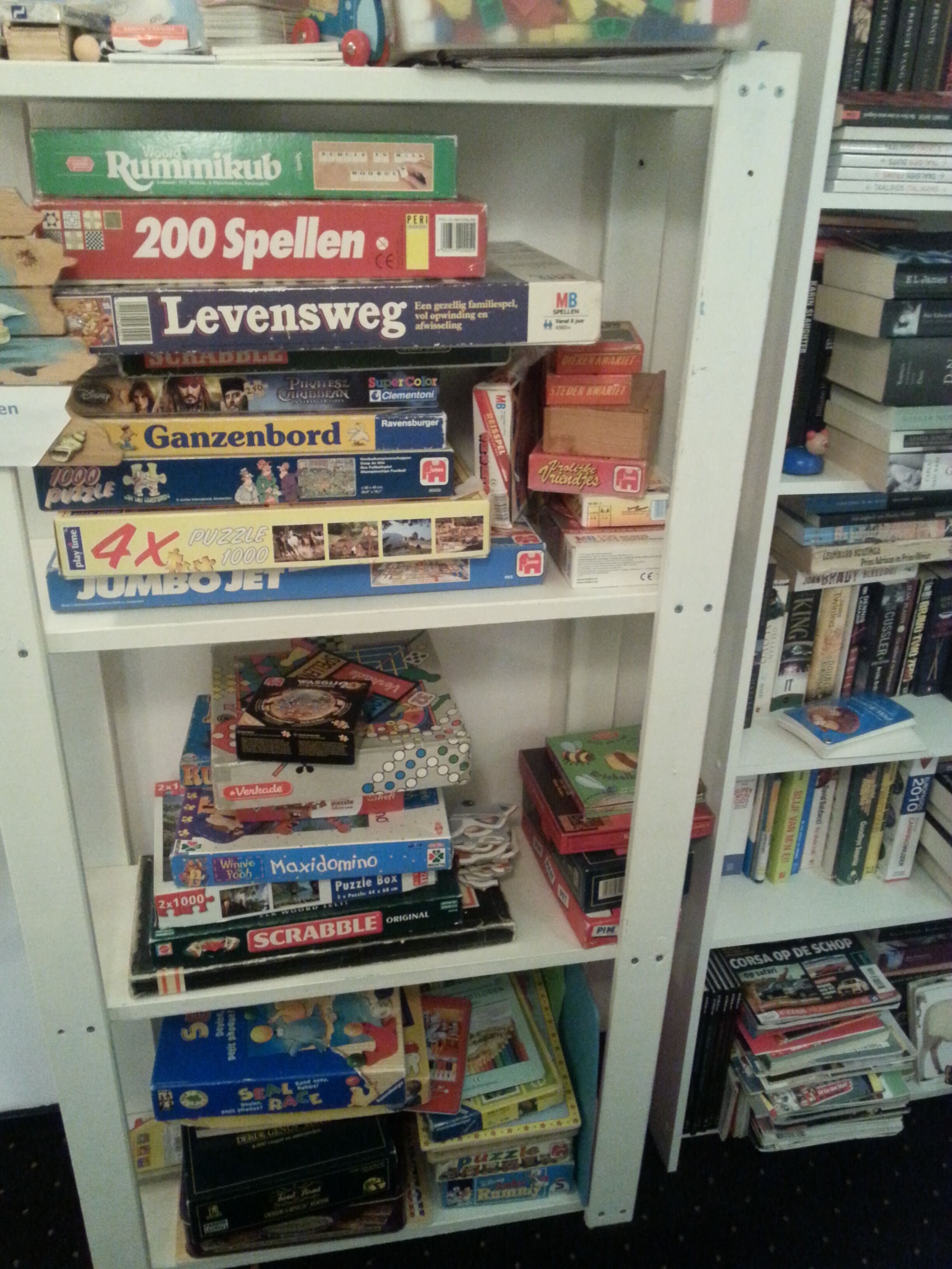 A shelf with various board games and puzzles.